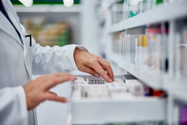 Male pharmacist choosing a medicine from the drawer, side view.